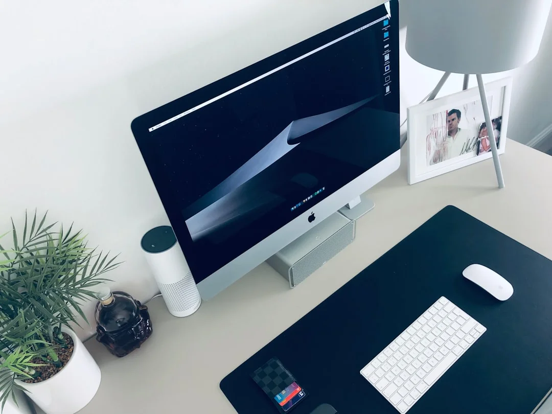 Vue en plongée d’un bureau de travail élégant avec deux écrans, un clavier, une souris et des accessoires modernes.