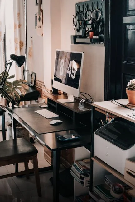 Un espace de travail moderne avec deux écrans d’ordinateur affichant des projets de web design, mettant en avant la technologie et la productivité.